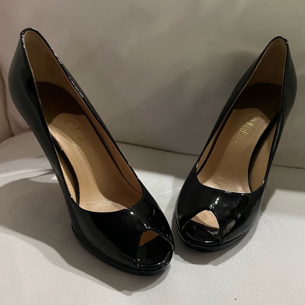 Cole Haan open toed pumps in black patent.